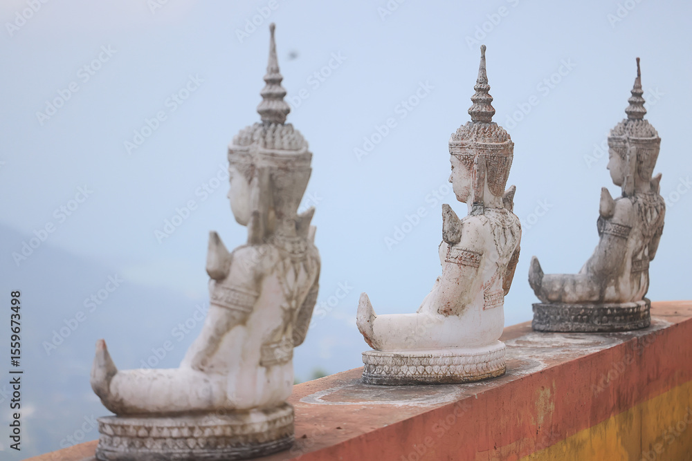 Fototapeta premium Buddha statues praying in a monastery against the sky in Koh Samui, Thailand