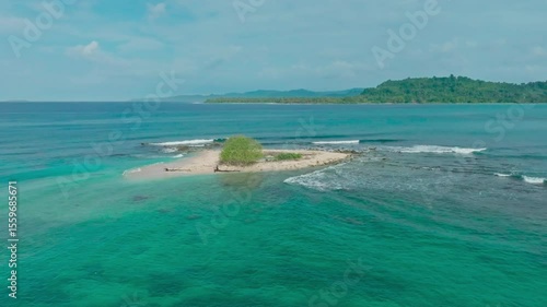 Cinematic aerial view of a beautiful small tropical island. Aerial view of a small island in the middle of a turquoise ocean