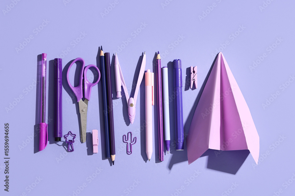 Fototapeta premium Composition with paper airplane and different school stationery on lilac background, closeup