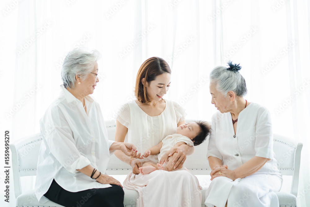 Obraz premium 赤ちゃんを抱っこするお母さんと2人のシニア女性