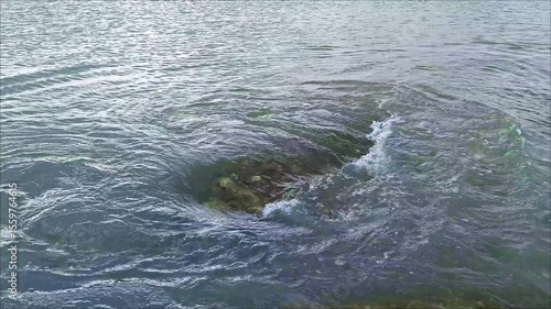 A pool of water in calm sea waters and visible movement that creates waves
