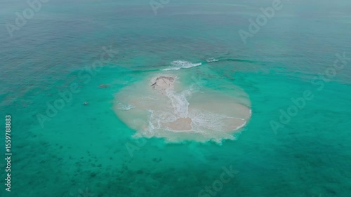 Cinematic aerial view of a beautiful small tropical island. Aerial view of a small island in the middle of a turquoise ocean