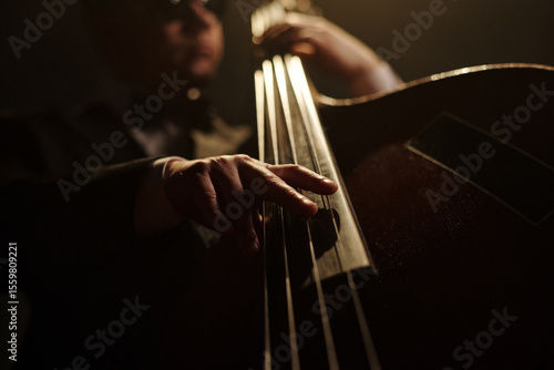 Photography Middle aged Caucasian man playing double bass on stage, close up of hand pluckin