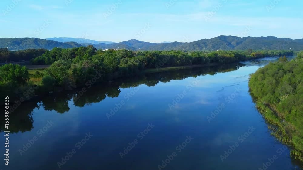 A drone top view of the river in woods. An aerial view of an spring forest, Aerial view of calm river between fields and reflection of green trees, beautiful blue sky and clouds in water in Africa. A drone top view of the river in woods. An aerial view of an spring forest, Aerial view of calm river between fields and reflection of green trees, beautiful blue sky and clouds in water in Africa.