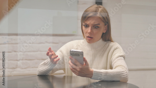 Young Woman with Trading Loss on Phone at Workspace