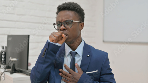 Sick Young Businessman Coughing at Work