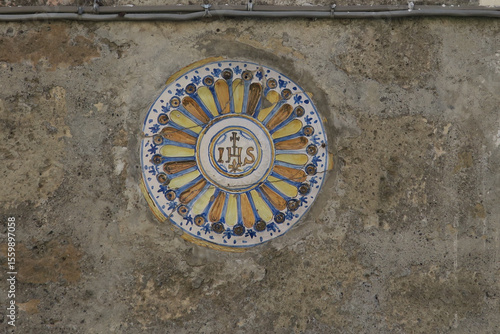 ceramic tile with the letters IHS : Iota Eta Sigma or Jesus Hominum Salvator