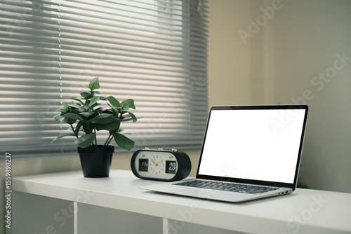 Wallpaper Mural Office desk featuring laptop with blank screen, a potted plant, and a vintage flip clock Torontodigital.ca