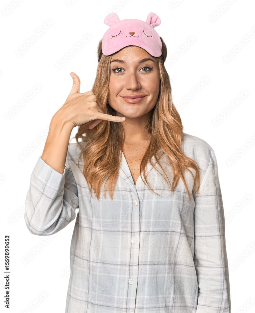 Blonde in pajamas with sleep mask showing a mobile phone call gesture with fingers. Blonde in pajamas with sleep mask showing a mobile phone call gesture with fingers.
