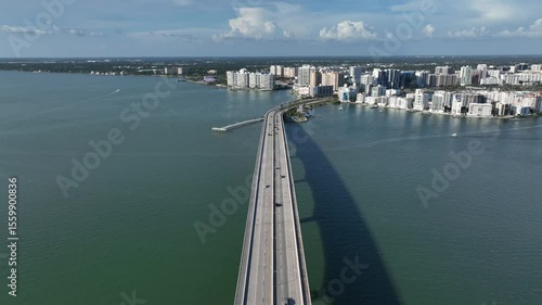 Wallpaper Mural Aerial view of a marina in Sarasota, FL, showing luxury boats docked against a backdrop of modern high-rise buildings under a clear blue sky. Wide shot. Torontodigital.ca