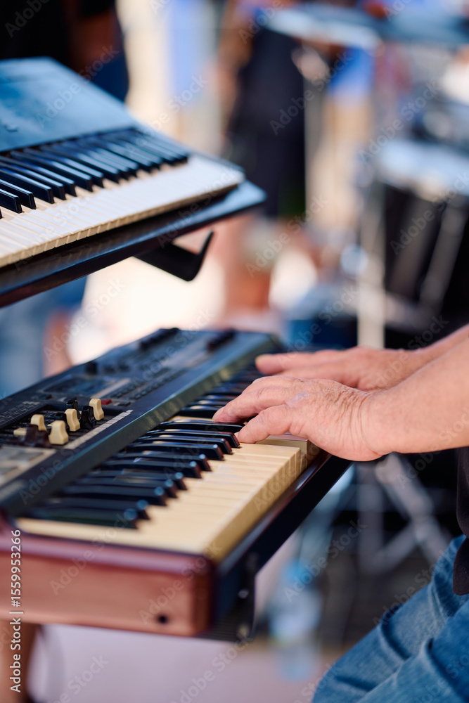Obraz premium Rock band performs live with keyboardist at outdoor festival in summer