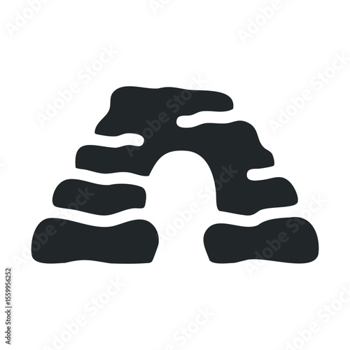 Silhouette of archaeological cave entrance with rocks and archway.