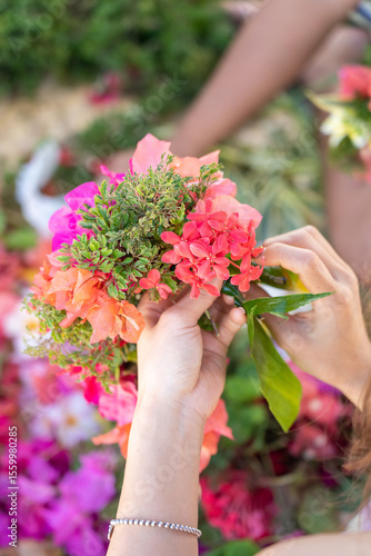 A woman’s hand holding beautiful, colorful flowers