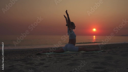 Woman Doing Yoga Split Pose on Beach at Sunset