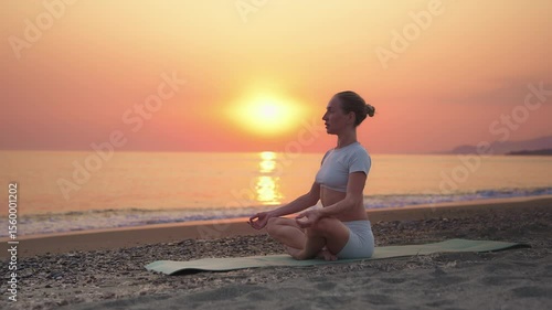 Woman Meditating on Beach at Sunset