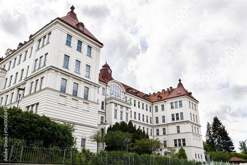 Historic rectorate of Brno University of Technology, white Neo-Renaissance façade with red mansard roofs against cloudy sky 