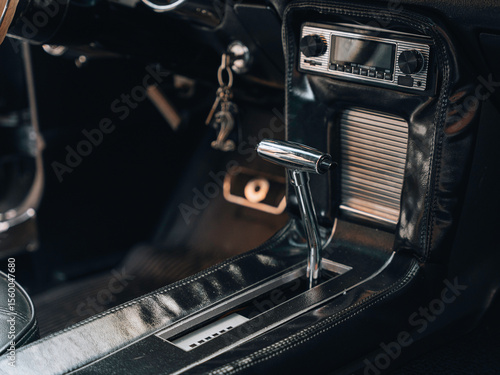 Close-up interior view of a classic American muscle car automatic transmission shifter with chrome finish and vintage radio – retro automotive design captured for restoration, martketing press.