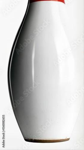 Striking studio shot of a single white bowling pin with red bands against a bright white background creates a clean minimalist image.