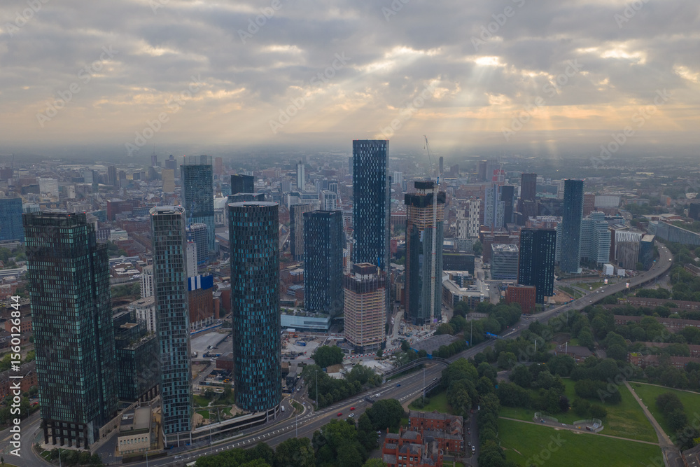 Fototapeta premium Aerial image of Manchester cityscape in the morning with sun-rays breaking through the clouds 
