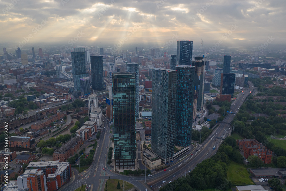 Fototapeta premium Aerial image of Manchester cityscape in the morning with sun-rays breaking through the clouds 