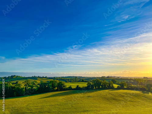 Golden hour light over green fields and rolling hills in County Meath, Ireland