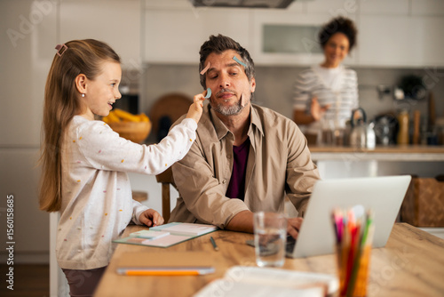 Playful Family Interaction During Work and Study Time in Kitchen Setting