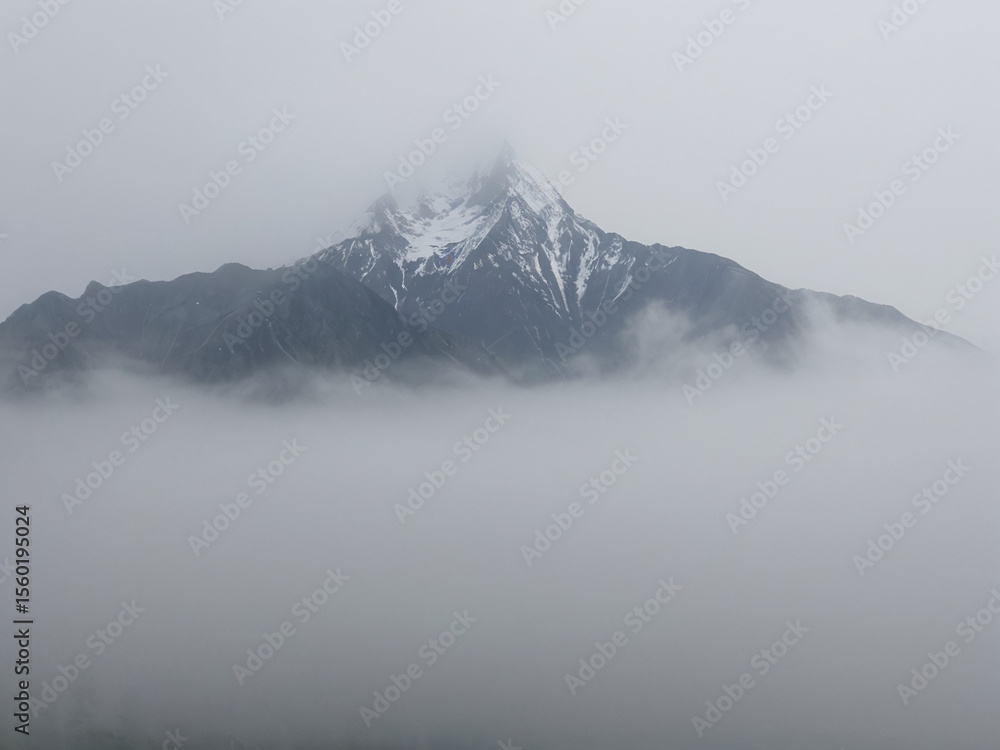 Fototapeta premium Enigmatic Mountain Peak shrouded in Mist A Serene Landscape Photography