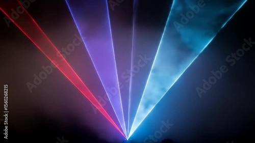Dynamic Laser Light Show: Red, Blue, and Purple Beams in Smoky Night Sky
