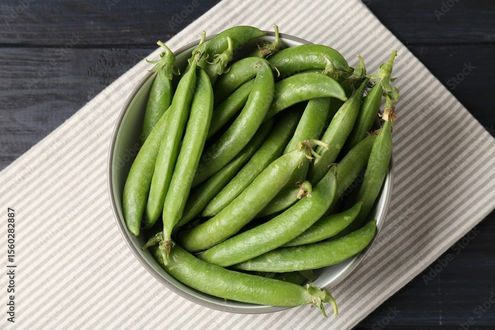 Fresh ripe green peas on black wooden table, top view Fresh ripe green peas on black wooden table, top view