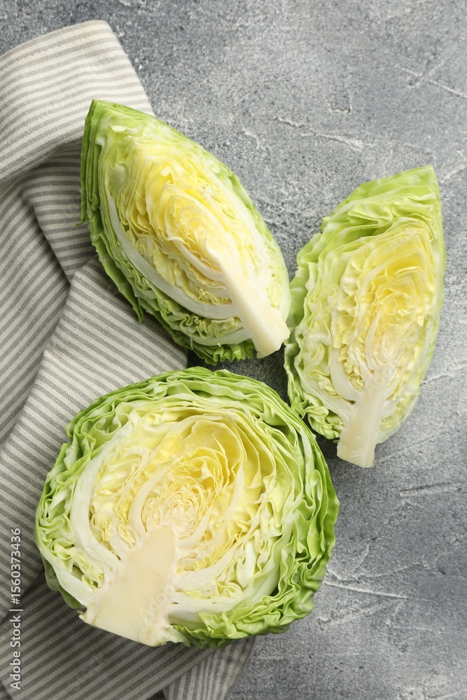 Obraz premium Pieces of fresh cabbage on grey table, flat lay