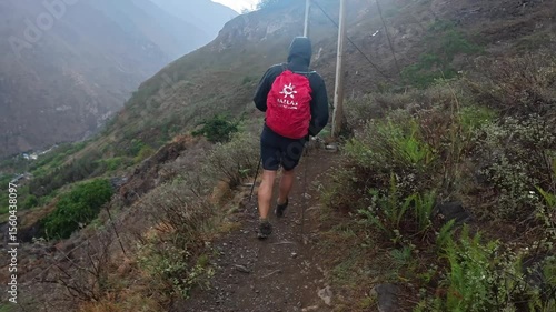 Lone Caucasian traveler exploring the dramatic landscape of Tiger Leaping Gorge in Yunnan, China