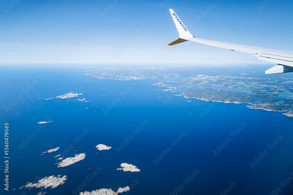 Obraz premium View from the window of a Ryanair plane over the sea and land of Norway.