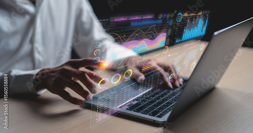 Person interacting with a laptop displaying futuristic transparent data charts and graphs, illustrating advanced data analytics and technology use.