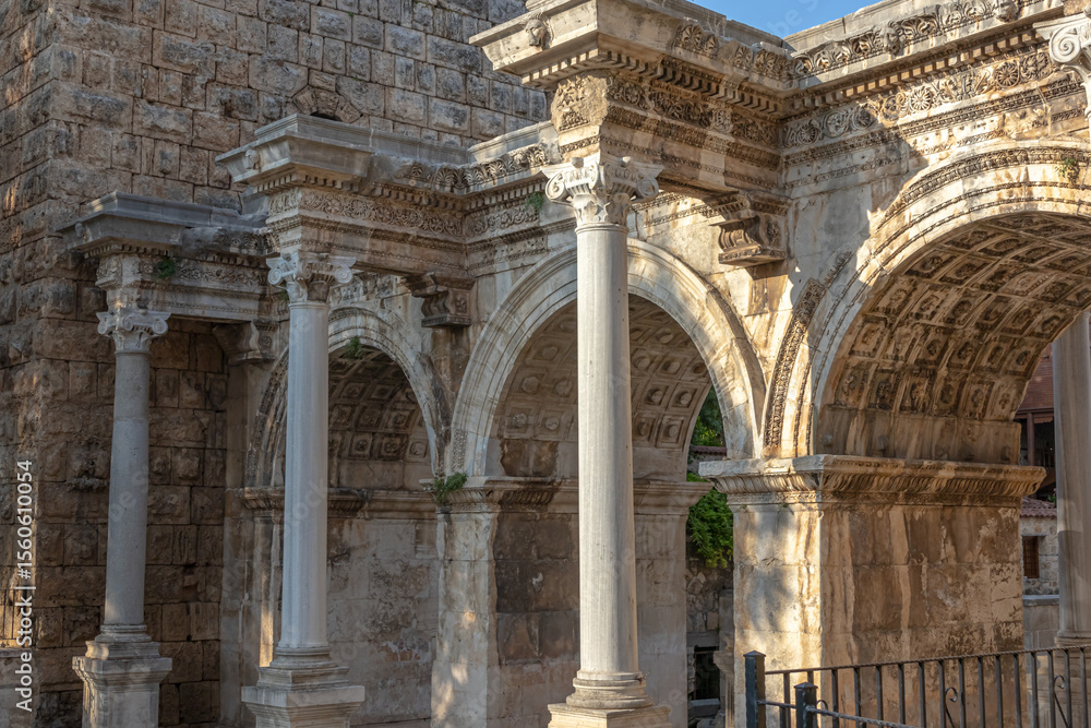 Obraz premium The Arch of ancient times. The famous gate, built in honor of the ancient Roman emperor. The Arc de Triomphe in the Kaleici area. Hadrian's Gate in Antalya. The arch is decorated with carved patterns.