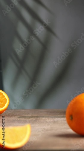A woman's hand takes a glass of cold bumble coffee out of the frame. Refreshing drink with espresso, caramel syrup, fresh orange juice and ice. Sliced ​​orange on the table