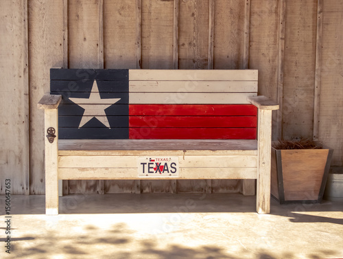 Texas themed wooden bench on the porch with Texas Flag painted on the back and a bottle opener on one of the legs.