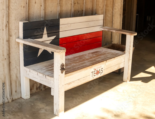 Texas themed wooden bench on the porch with Texas Flag painted on the back and a bottle opener on one of the legs.