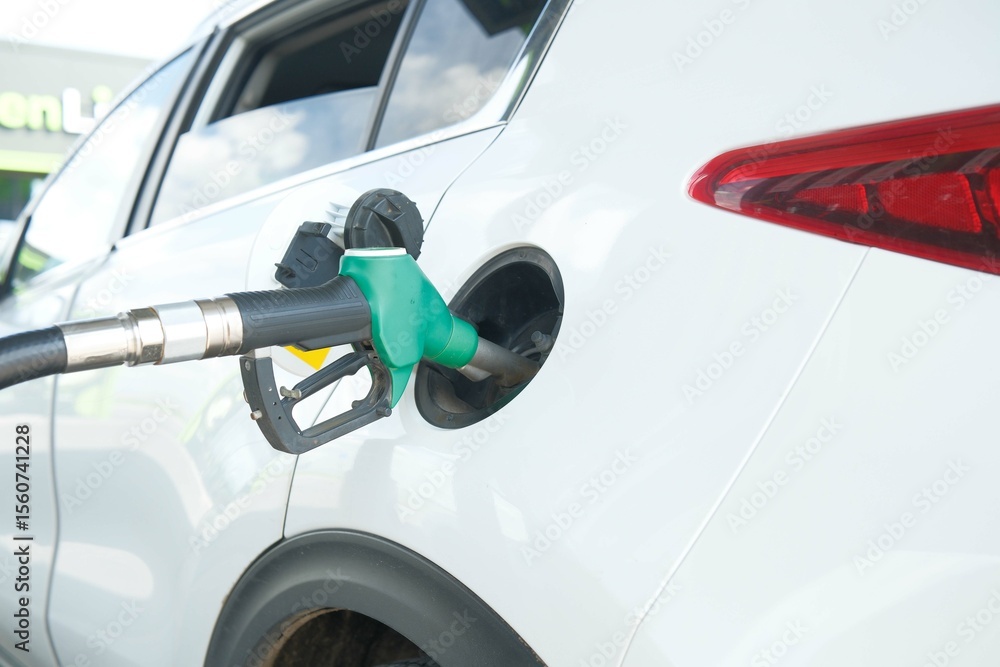 Fototapeta premium Refueling a White SUV at a Gas Station, ensuring the vehicle is powered for the road ahead