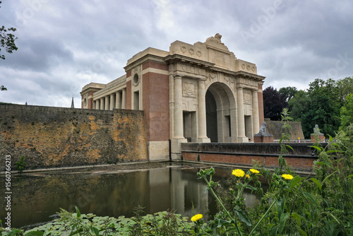 Bild auf Leinwand Menin Gate, Ypres, Belgium: War memorial, pond, and cloudy sky.