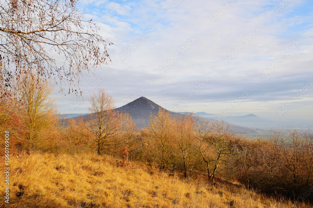 Naklejka premium Rolling Hills Illuminated by Golden Light Under a Tranquil Sky