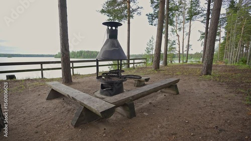 Relax by the tranquil sea water in Porvoo, Finland. Enjoy the scenic beauty of spring surrounded by tall trees and a charming grill area. Perfect for unwinding in nature.	
