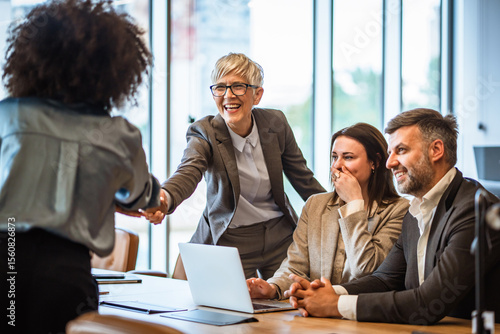 senior businesswoman handshake with african american client