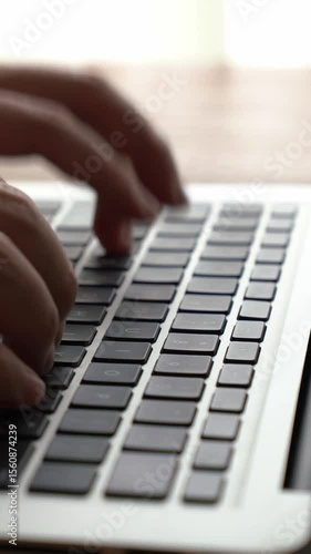 Businessman hand work on capable laptop computer at office table close up shot and selective focus at middle section of laptop computer keyboard while typing and working