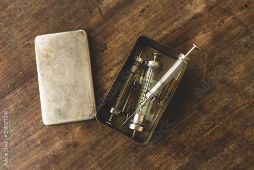 Glass medical syringes on a wooden table.A table with syringes in an old apartment.Problems of drug addiction.