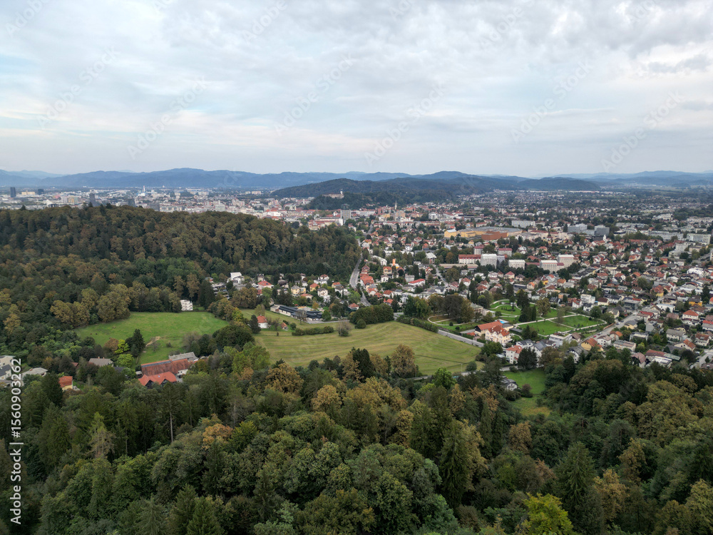 Obraz premium aerial view of ljubljana slovenia (european capital city in europe) castle on hill colorful roofs suburban neighborhood with mountains apartment buildings trees green nature hills river