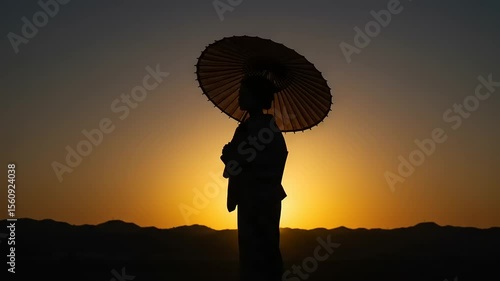 Silhouette of a person in traditional Japanese attire with an umbrella at sunset.