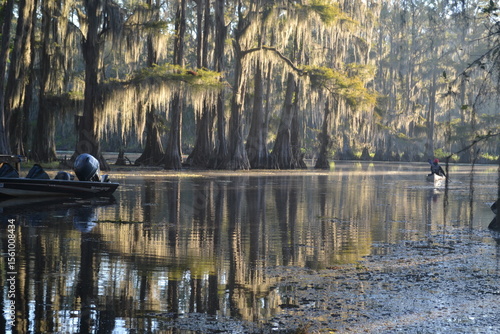 A man is kayaking on Caddo Lake in Texas at sunrise