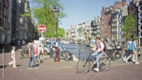 Wallpaper Mural Blurred cyclists and pedestrians along amsterdam canals, capturing the essence of dutch urban life with bicycles against classic canal-side architecture in soft focus. Torontodigital.ca