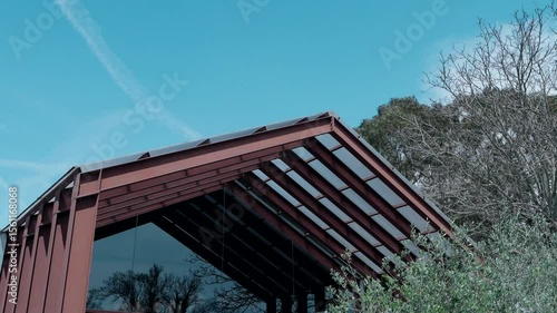 Wallpaper Mural angular glass roof reflects trees under bright sky and bare branches Torontodigital.ca