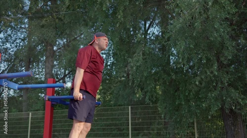 Elderly man exercising. Fitness and strength for seniors. Dips on bars.